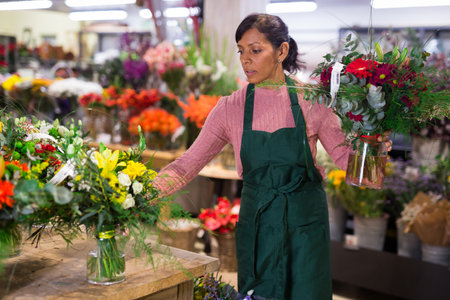 Latin woman florist working in floral shopの写真素材