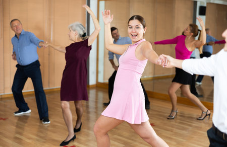 Young girl enjoying swing with partner in dance studio