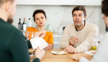 Two married couples playing card game poker