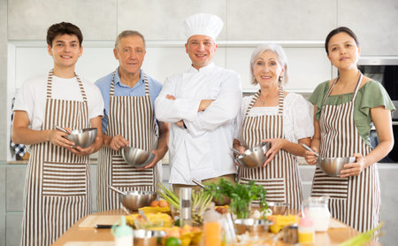Group portrait of a chef and his students in kitchen