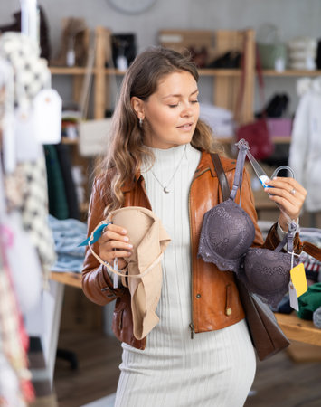 Girl chooses bra in fashionable clothing boutiqueの写真素材