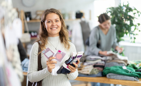 Female shopper selects socks in fashionable clothing boutiqueの写真素材