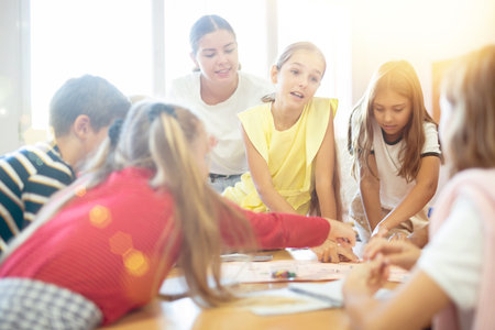 Teacher and schoolchildren play in school classの写真素材
