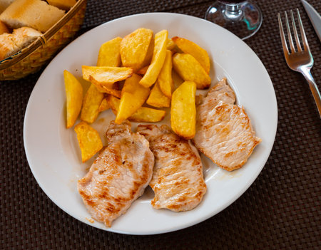 Tasty grilled pork meat with boiled potatoes served on tableの写真素材