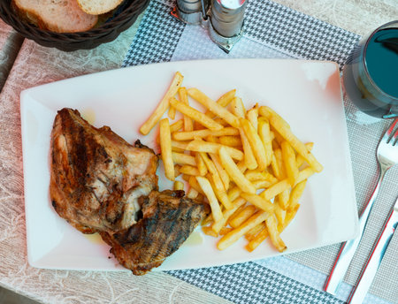 Grilled chicken with side dish of crispy French friesの写真素材