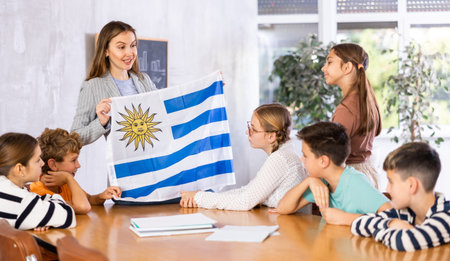 Teacher showing Uruguay flag to group of schoolchildrenの写真素材