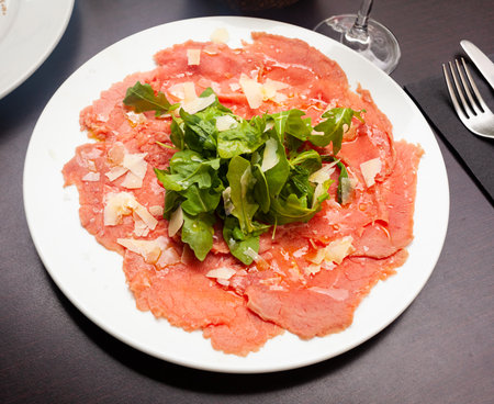 Raw veal meat carpaccio with cheese and fresh arugulaの写真素材