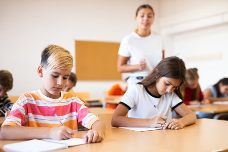 School boy sitting at the desk in classroom at lesson in primary school