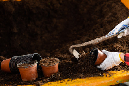 Farmer putting a black soil in potsの写真素材