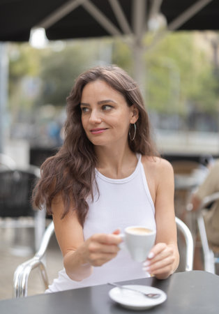 Young woman drinking coffee in cafeの写真素材