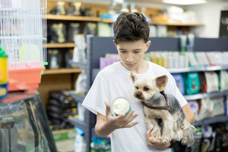 Focused preteen boy choosing canned dog food for Yorkie in pet store