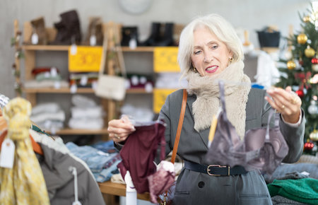 Mature woman choosing a bra in a Christmas shopの写真素材