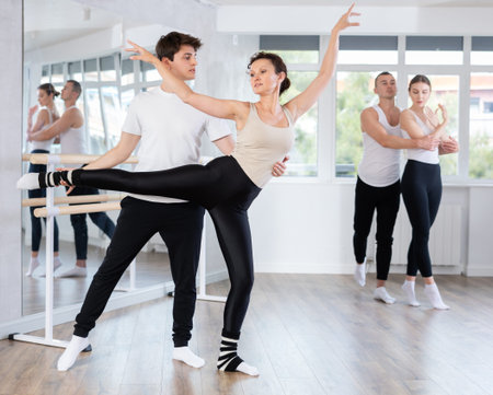 Amateur ballet partners mastering paired technique at group class