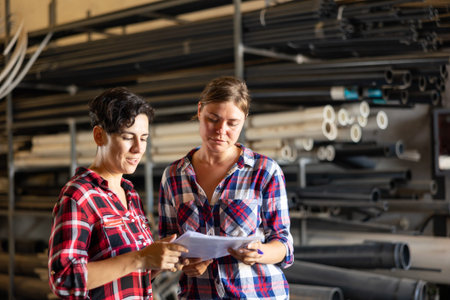 Female warehouse owner and manager keep track of products in warehouse