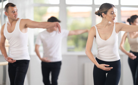 Woman leading ballet class with amateur dancers in studio