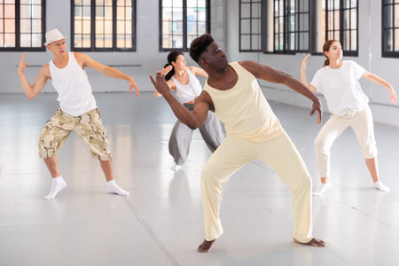 People practicing vigorous lindy hop movements in dance class