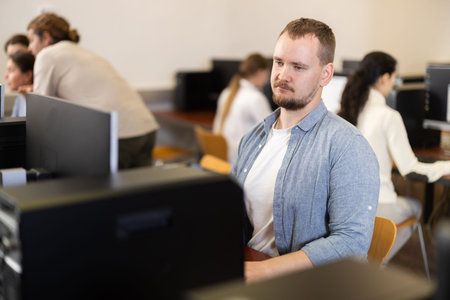 Portrait of concentrated man during lesson in computer room of school computer class