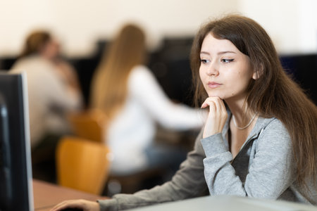 Portrait of female student studying in university computer classの写真素材