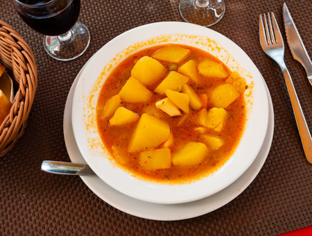 Potatoes with cuttlefish in broth served on platterの写真素材