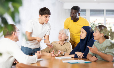 Interested guy discussing study topics with group of coursematesの写真素材