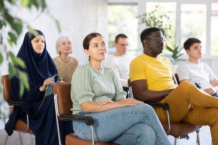 Young woman listening to lecture while sitting on chair in office