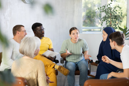 Group of multinational people have discussion while sitting on chairs in circleの写真素材