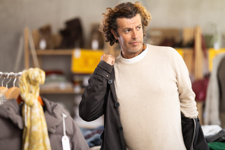 Man trying on black jacketの写真素材