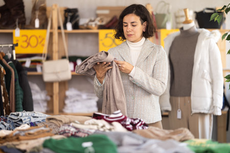 Woman at the counter in the store choosing pantsの写真素材