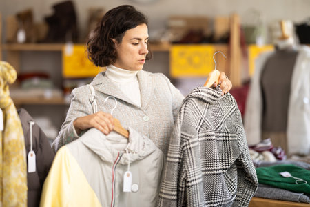 woman chooses outerwear at a sale in a showroomの写真素材