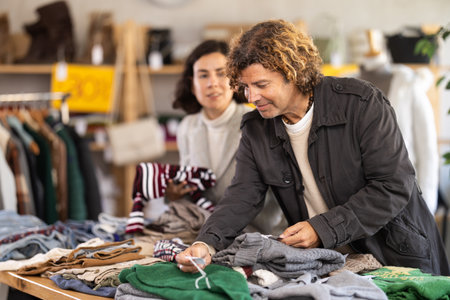 International couple search and choose knitted sweater in storeの写真素材