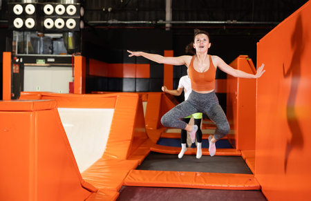 Middle-aged woman practice jumping on trampolines at trampoline center