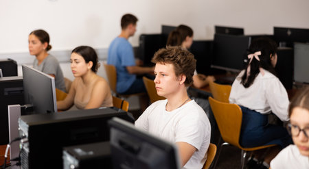 Clever focused male teenager solving tasks of computer science in the auditoryの写真素材