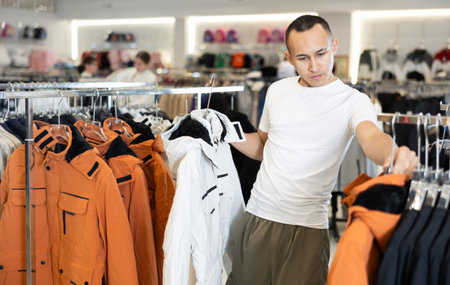 Young boy choosing casual jacket in clothing store