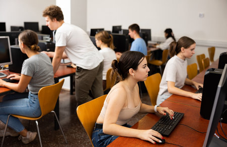 Concentrated Latin female student using PC and studying computer science in the classroomの写真素材