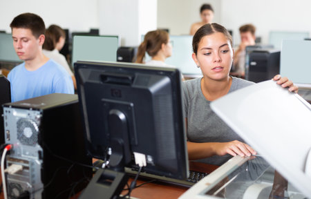 Female teacher uses a scanner in computer lab at schoolの写真素材