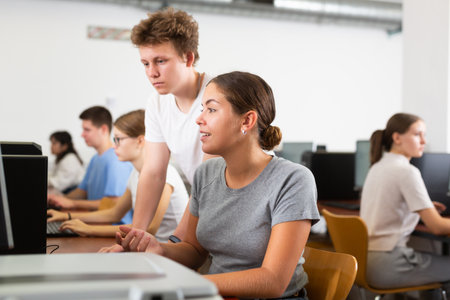 Schoolboy and teacher using PC in computer classの写真素材