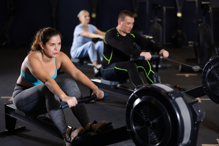 Sporty young woman using machine in gymの写真素材