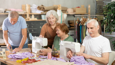 Elderly female showed group of elderly people how to sew on machineの写真素材