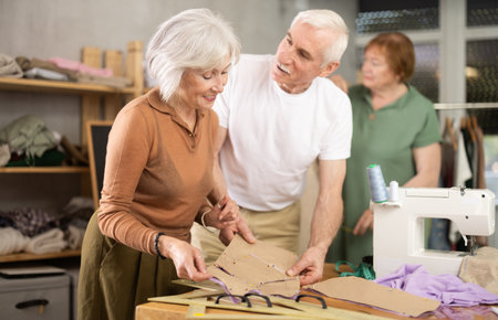 Woman and man discussing patterns with fabric in training sewing workshopの写真素材