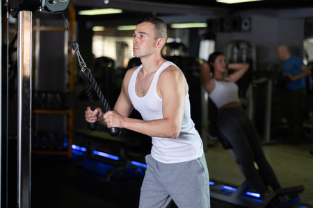 Man in sportswear training on rope loop simulator