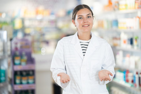 Female pharmacist in medical uniform posing while working in pharmacyの写真素材