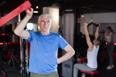 Elderly athletic man posing in gym