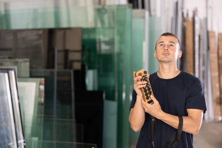 Man operating machinery with remote control in glass workshop