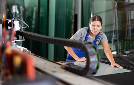 Glass workshop - woman marks glass for cutting with glass cutterの写真素材