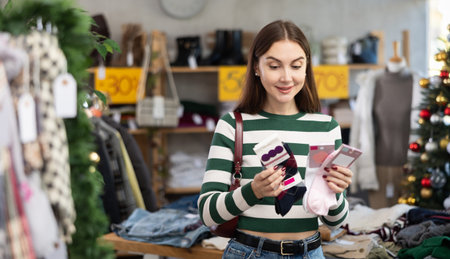 Woman client looks at products in store, choose closely socks
