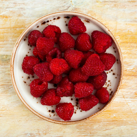 Lots of fresh sweet red raspberries arranged together representing concept of healthy diet