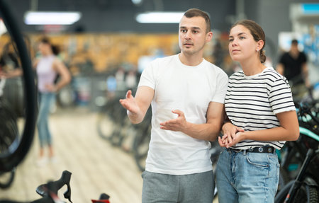 Young positive pair choosing sport bike in bicycle storeの写真素材