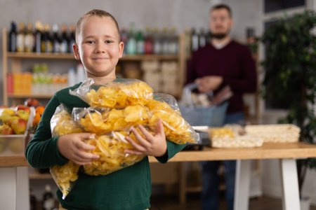 Boy choosing chips in grocery store