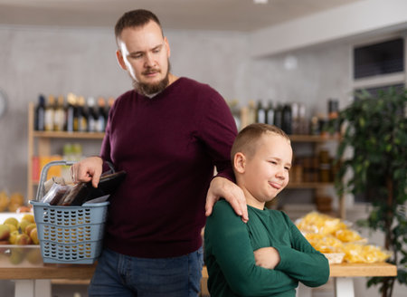 Dad dragging his little son behaving capricious in marketの写真素材