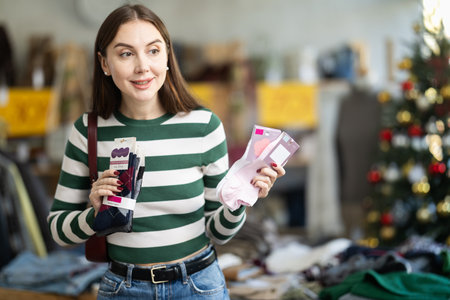 Positive young woman choosing socks in clothing storeの写真素材